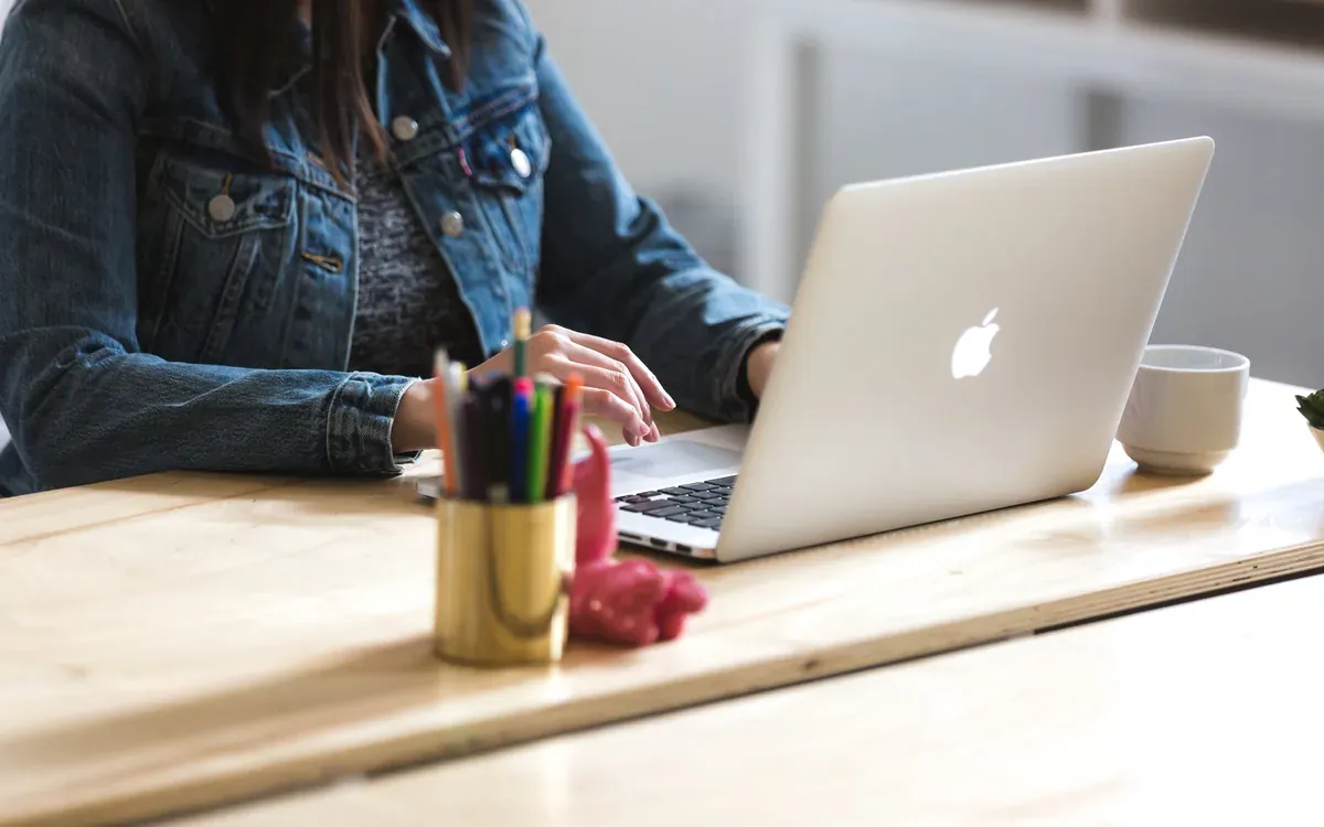 A workspace with a laptop and notes on a bright table.