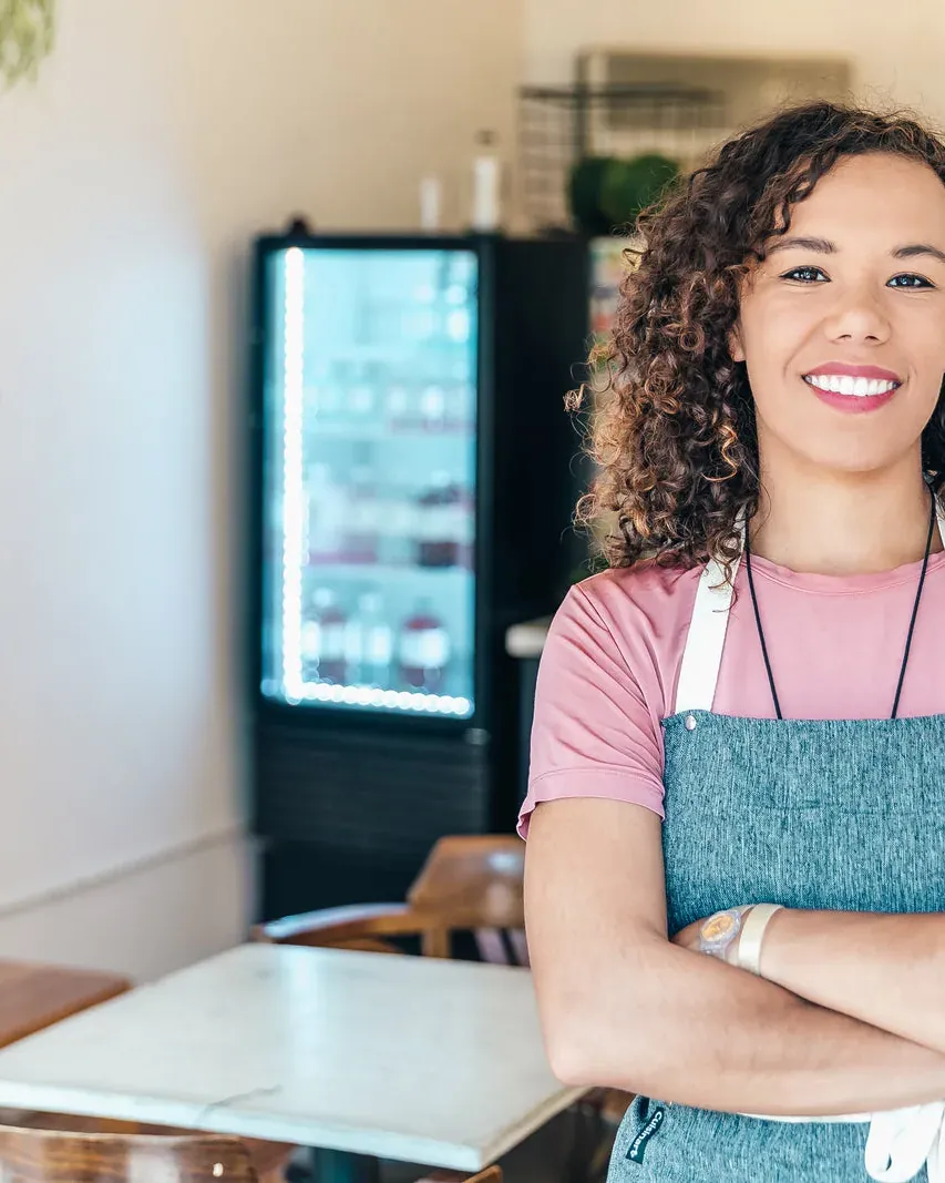 The owner of a coffee shop stands in her own place.