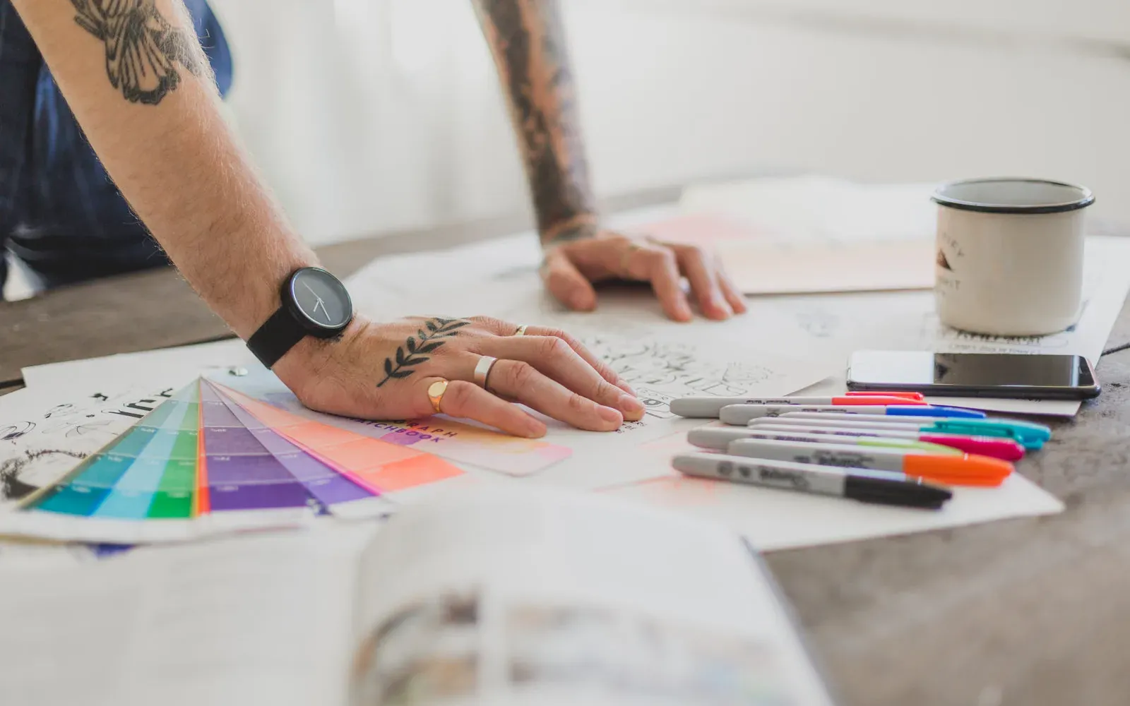 A designer works with colour swatches at a project table.