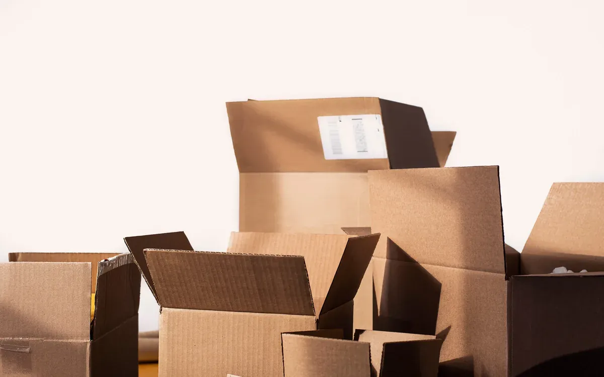 Cardboard boxes being packed on a light surface.